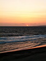 Picture of sun setting over the Pacific Ocean from a beach.