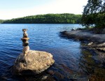 Stack of rocks next to a lake.